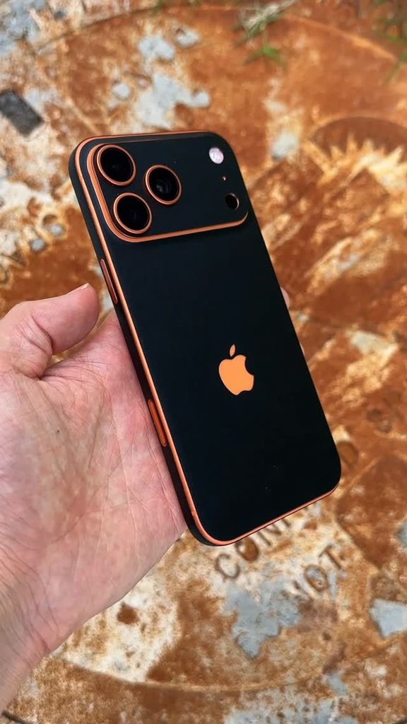 iPhone 17 Pro Max with a matte black skin and orange camera accents